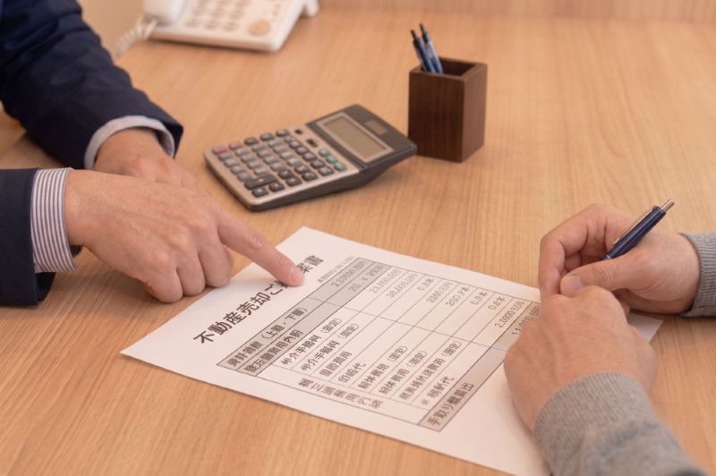 売却ご提案書を指し示して説明する手元